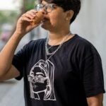 A stylish woman drinking traditional chai outdoors in Ahmedabad, India.